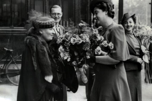Maria Montessori being greeted with flowers