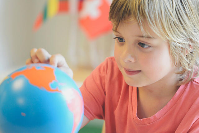 Child looking at globe