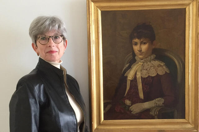 Helen Henny next to painting of Maria Montessori