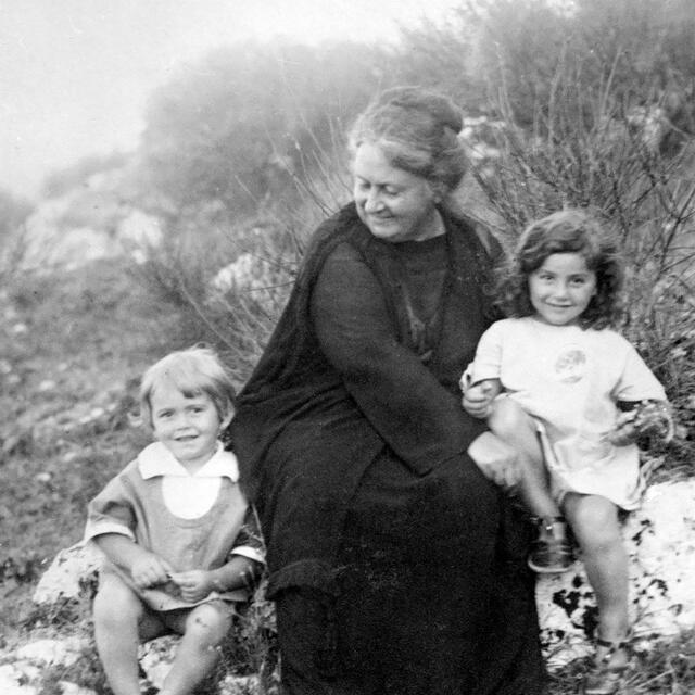 Maria Montessori with children at the beachside