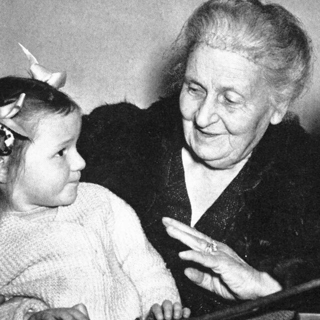 Maria Montessori with girl and BBC microphone in background 